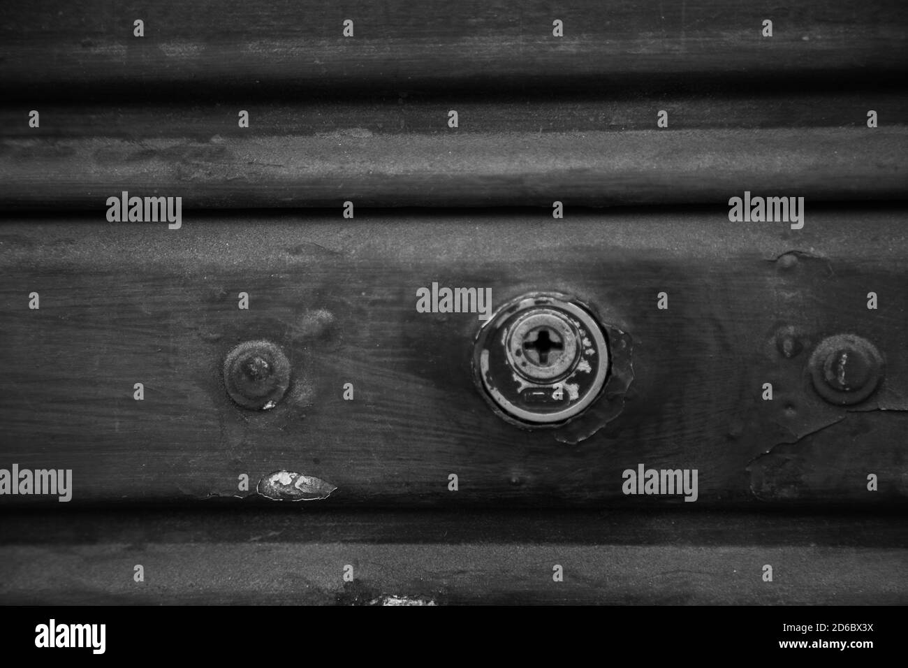 Greyscale closeup shot of a keyhole on a wooden door Stock Photo