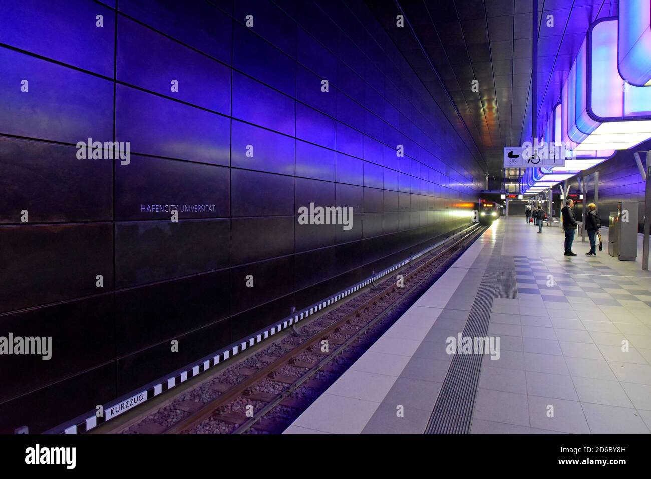 Passengers waiting for trains under the dramatic colour changing lighting at HafenCity Universität station on the Hamburg U-Bahn metro - Stock Image