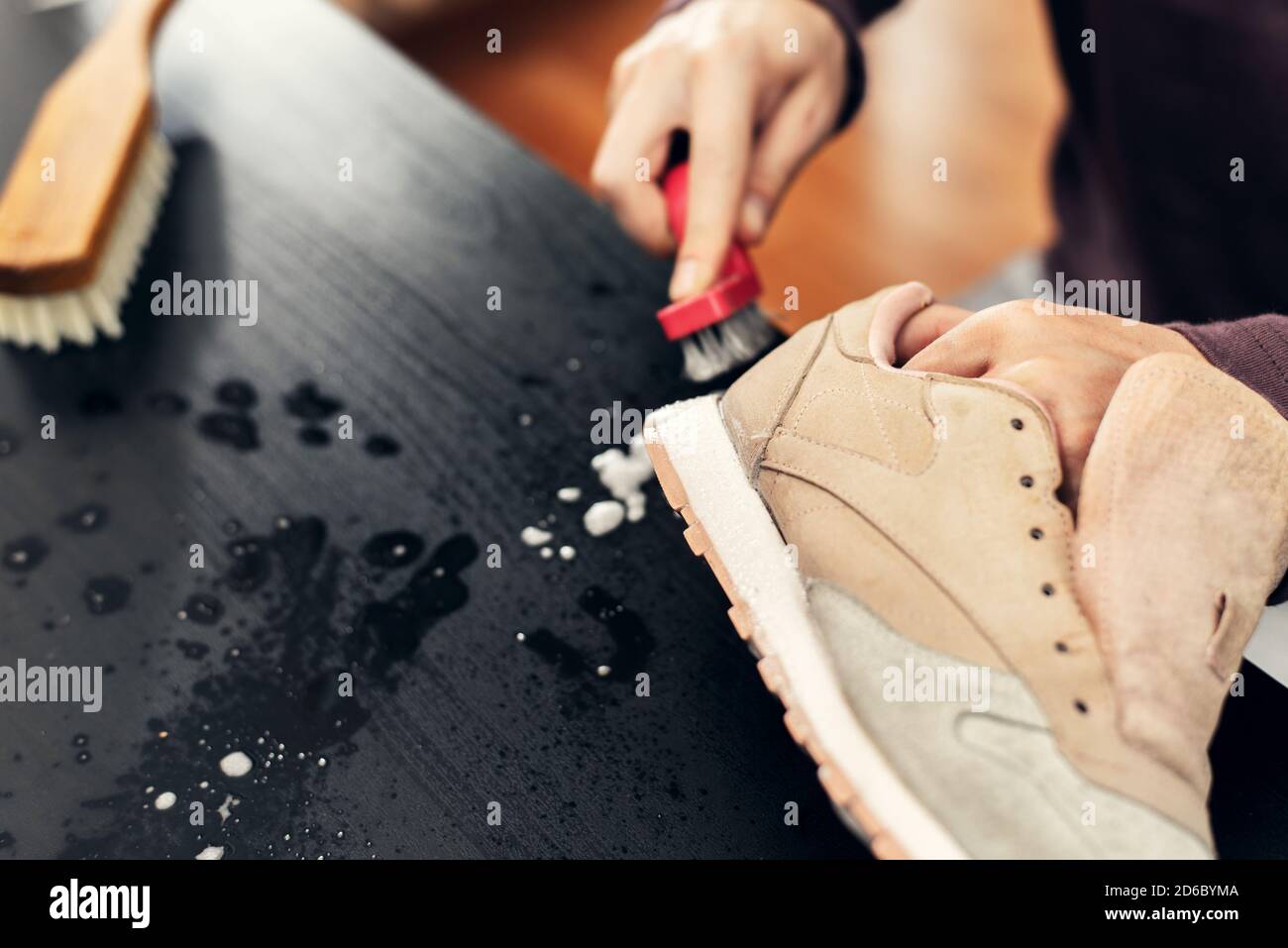 The master cleans the foam sole of the sneakers. washing the dirty