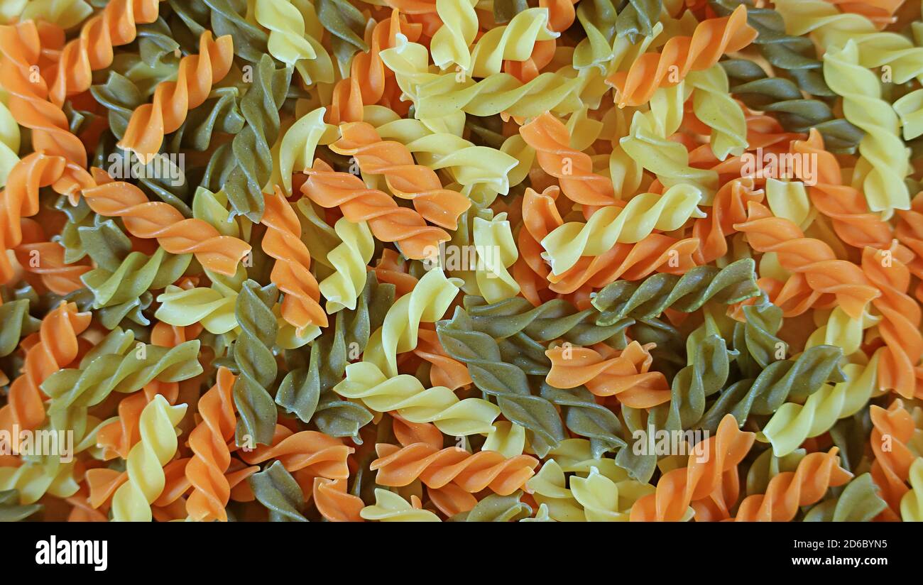 Top view of the pile of spiral shaped three-color fusilli pasta for