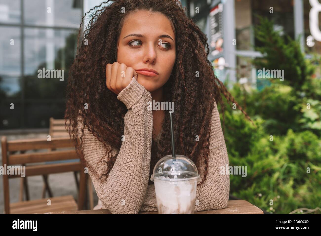 Sad young woman waiting someone at street cafe. Stock Photo