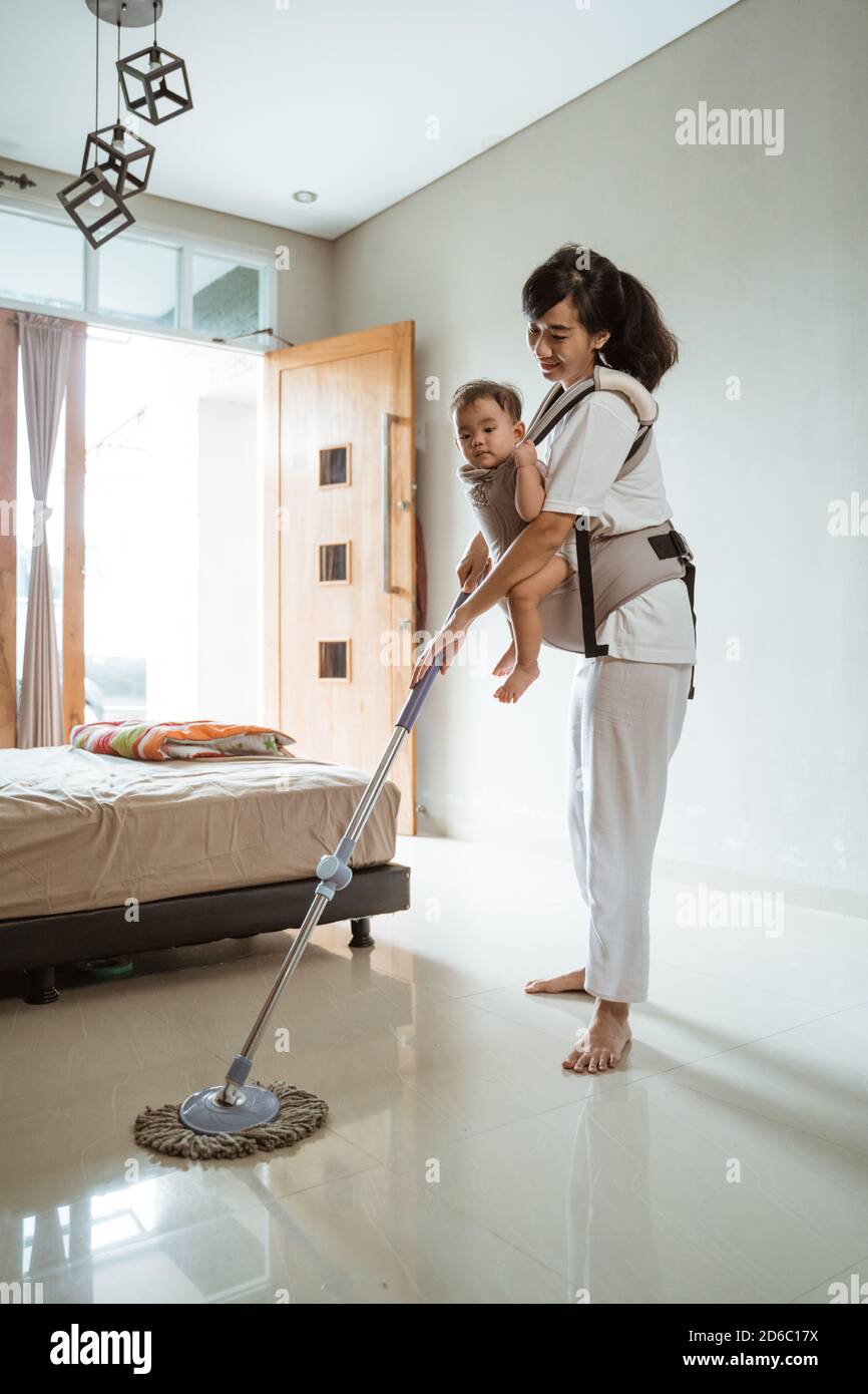 Mom and daughter are cleaning in the house, a woman carries a little