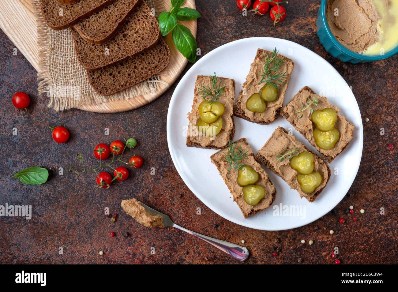 Canapes with chicken liver pate and pickled cucumbers on rye bread