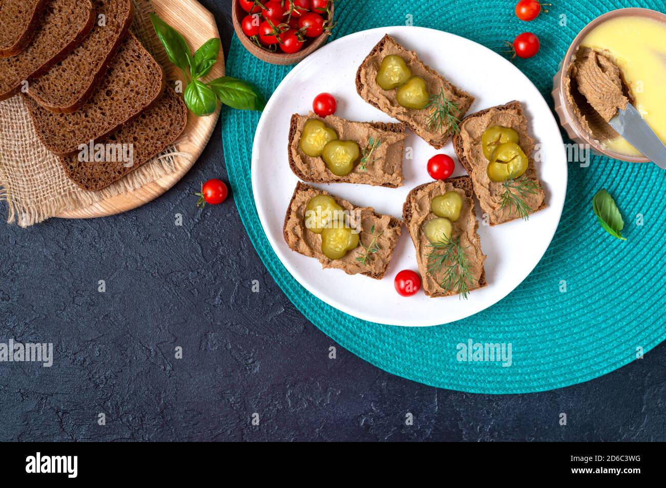 Canapes with chicken liver pate and pickled cucumbers on rye bread