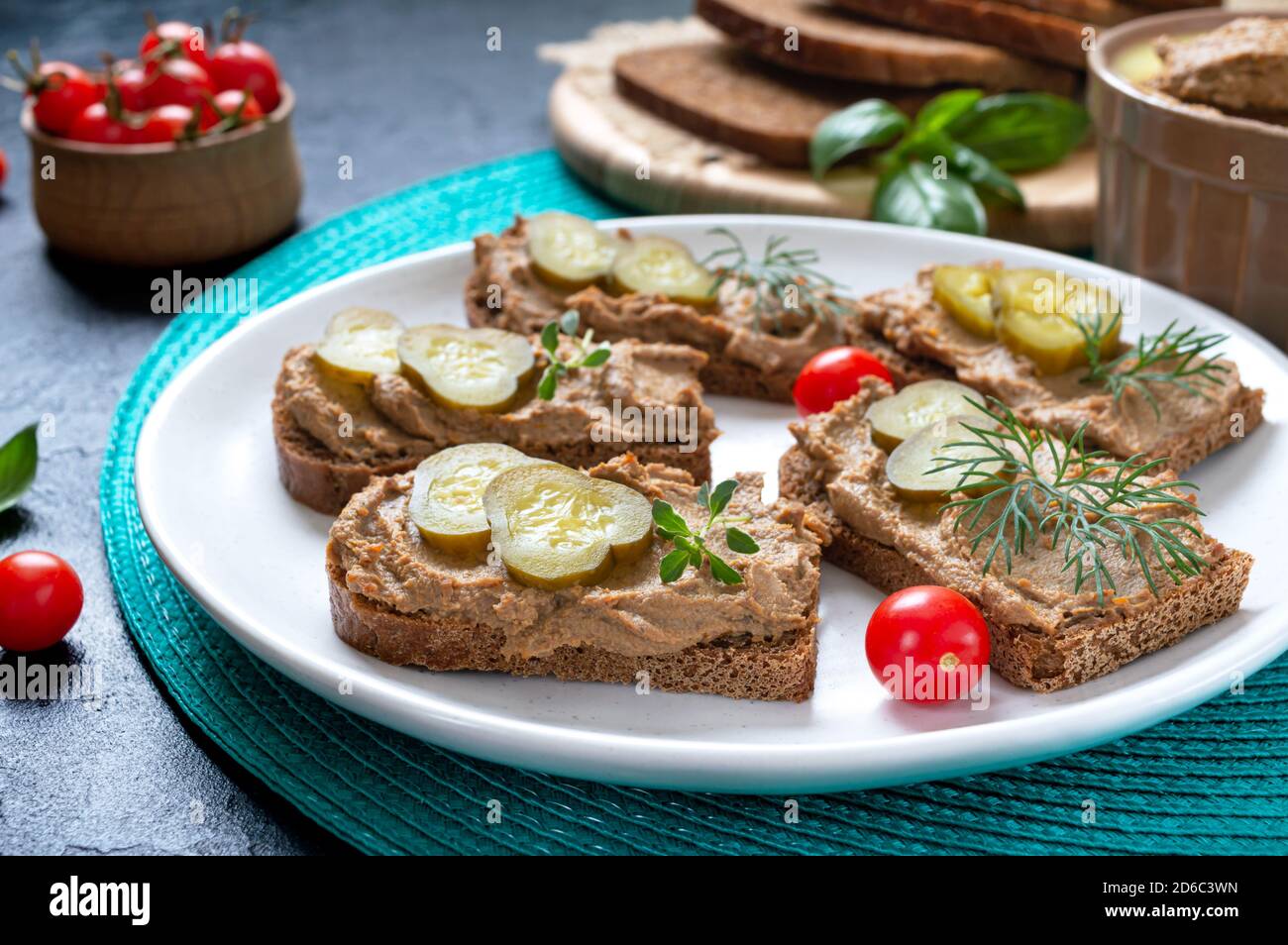 Canapes with chicken liver pate and pickled cucumbers on rye bread