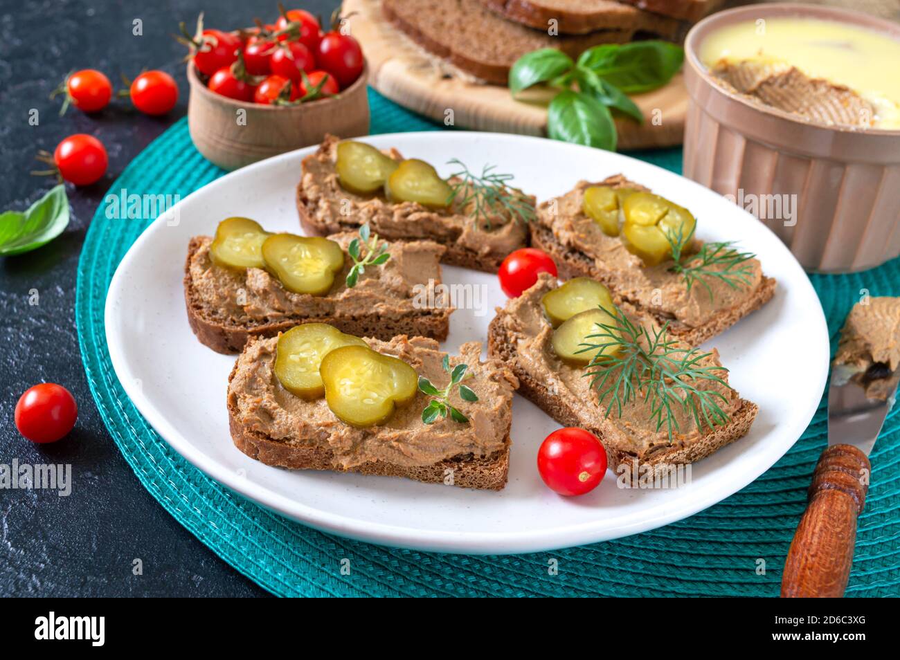 Canapes with chicken liver pate and pickled cucumbers on rye bread
