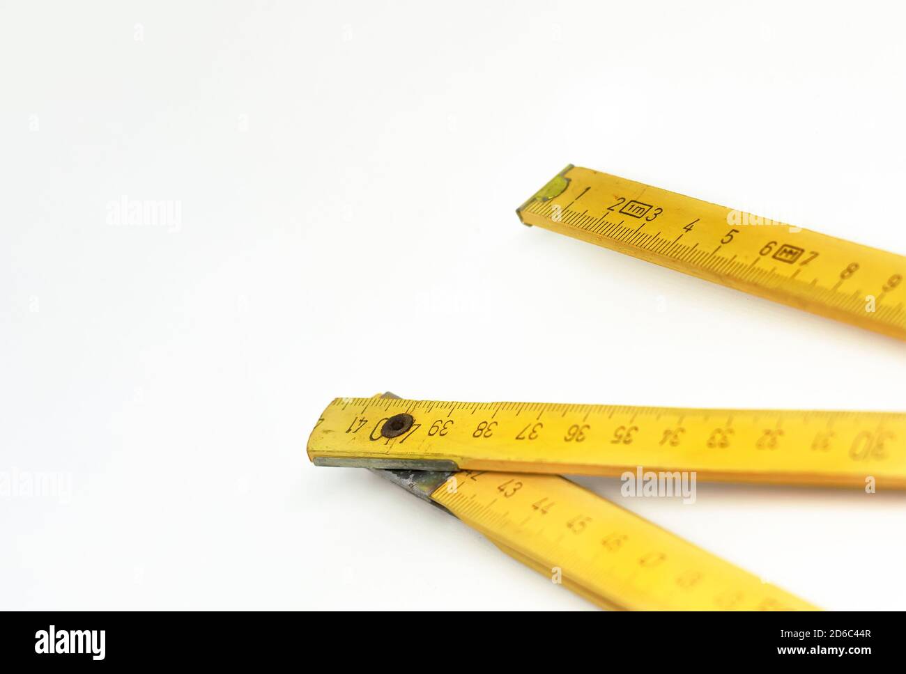 a yellow wooden folding ruler isolated on a white background. Measuring instrument. Construction and home renovation Stock Photo