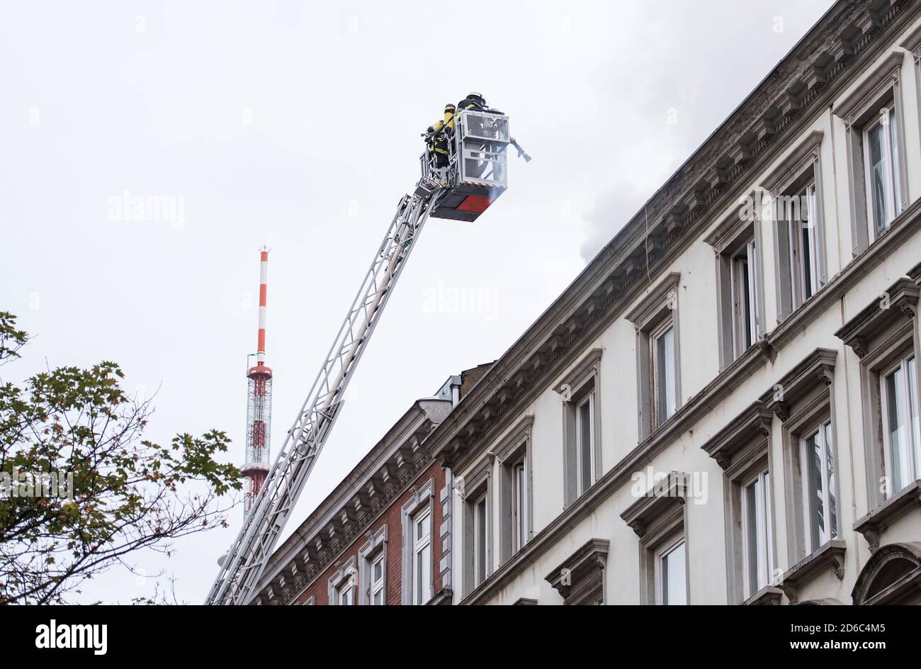 Hamburg, Germany. 16th Oct, 2020. A turntable ladder is in use in the Karolinenviertel in a roof truss fire. More than 100 firefighters have been extinguishing the fire in the narrow street since the morning hours. The inhabitants of the house were not injured in the fire. (to dpa 'Large fire brigade operation in roof truss fire in Karoviertel') Credit: Daniel Bockwoldt/dpa/Alamy Live News Stock Photo