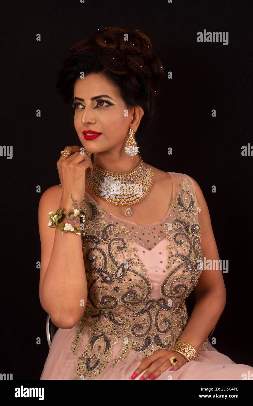 Indian model in pink and golden dress and jewelry. Looking away from camera  Stock Photo - Alamy