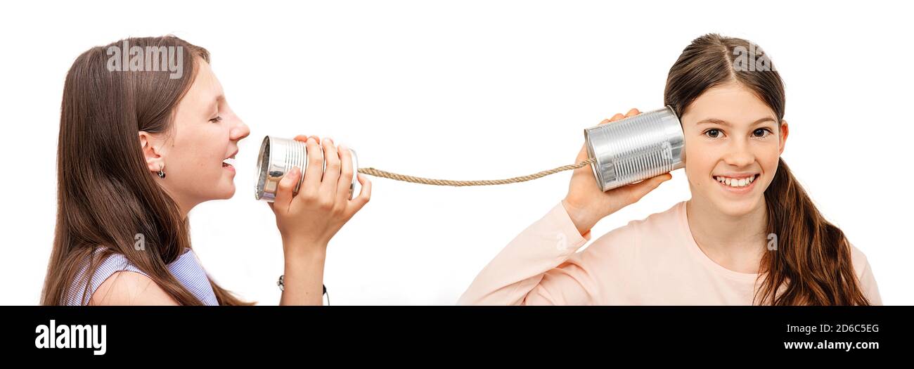 Positive kid with a tin can near the ear, playing the phone. I hear you well, child isolated on white, hearing concept Stock Photo