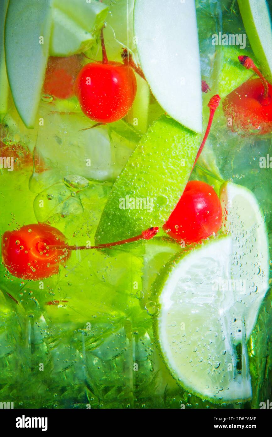 Freshness green drink cocktail with apple, lime and cherry in big jar, closeup Stock Photo
