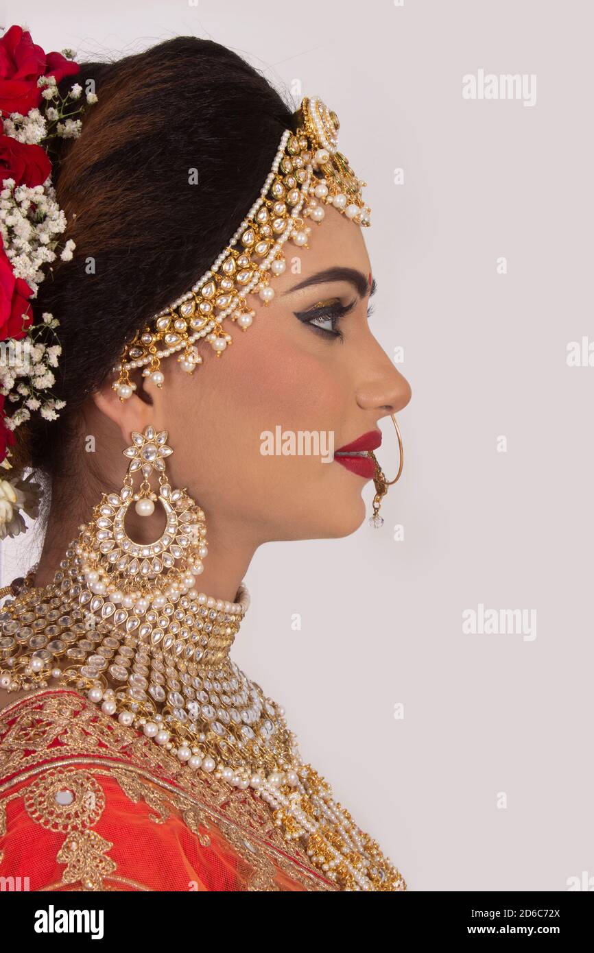 Side face closeup profile of Indian model in bridal wear with heavy jewelry Stock Photo