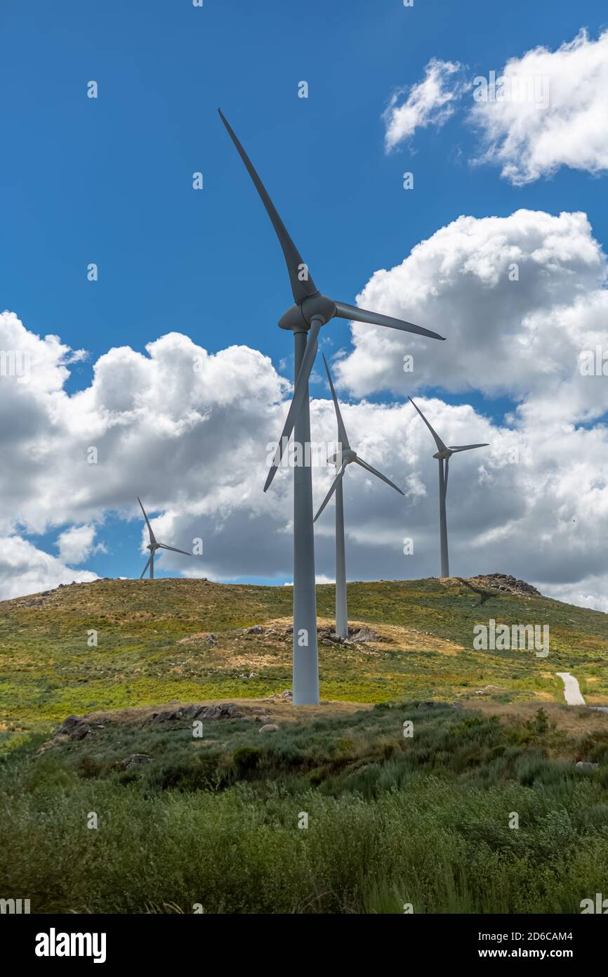 View of a wind turbines on top of mountains, cloudy sky as background ...