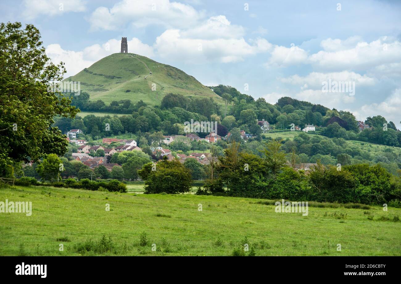 Idyllic countryside around Glastonbury Town with the Tor towering in the background. A beautiful summer day and lush green countryside with town view. Stock Photo