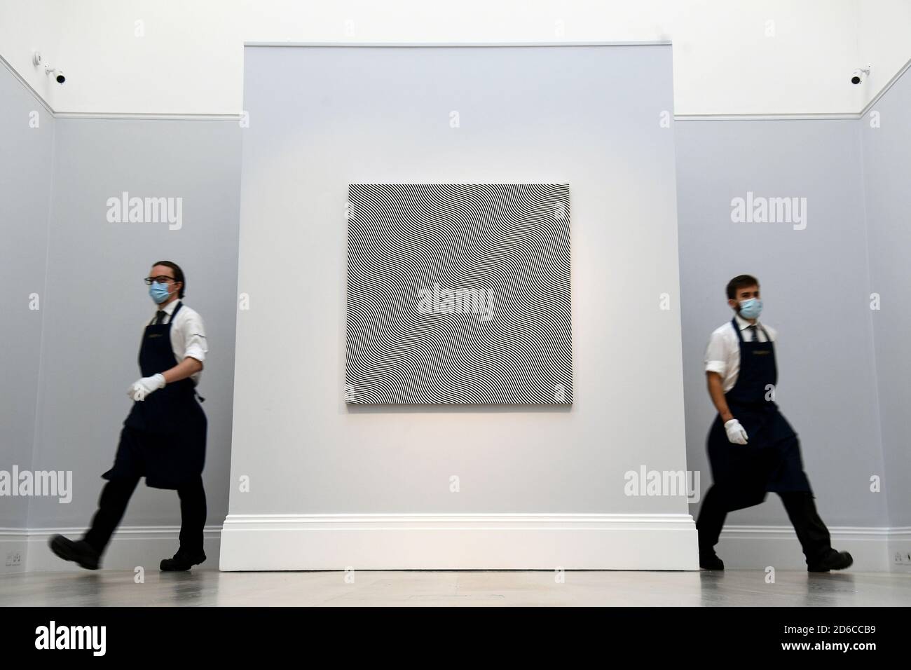 Gallery assistants with 'Untitled (Diagonal Curve)' by Bridget Riley, estimated at £5.5-£7.5 million, during a preview for Sotheby's Contemporary Art sale at Sotheby's in central London. Stock Photo