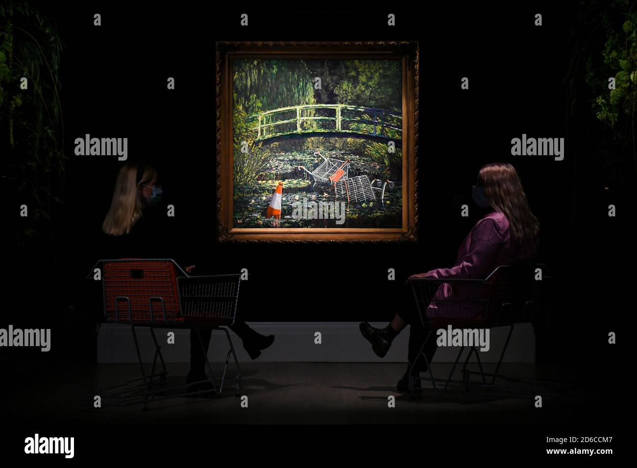 Gallery assistants with 'Show me the Monet' by Banksy, estimated at £3-5 million, during a preview for Sotheby's Contemporary Art sale at Sotheby's in central London. Stock Photo