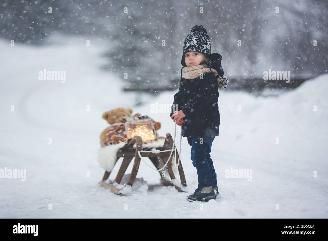 Cute boy playing with teddy bear in the snow, winter time. Little ...