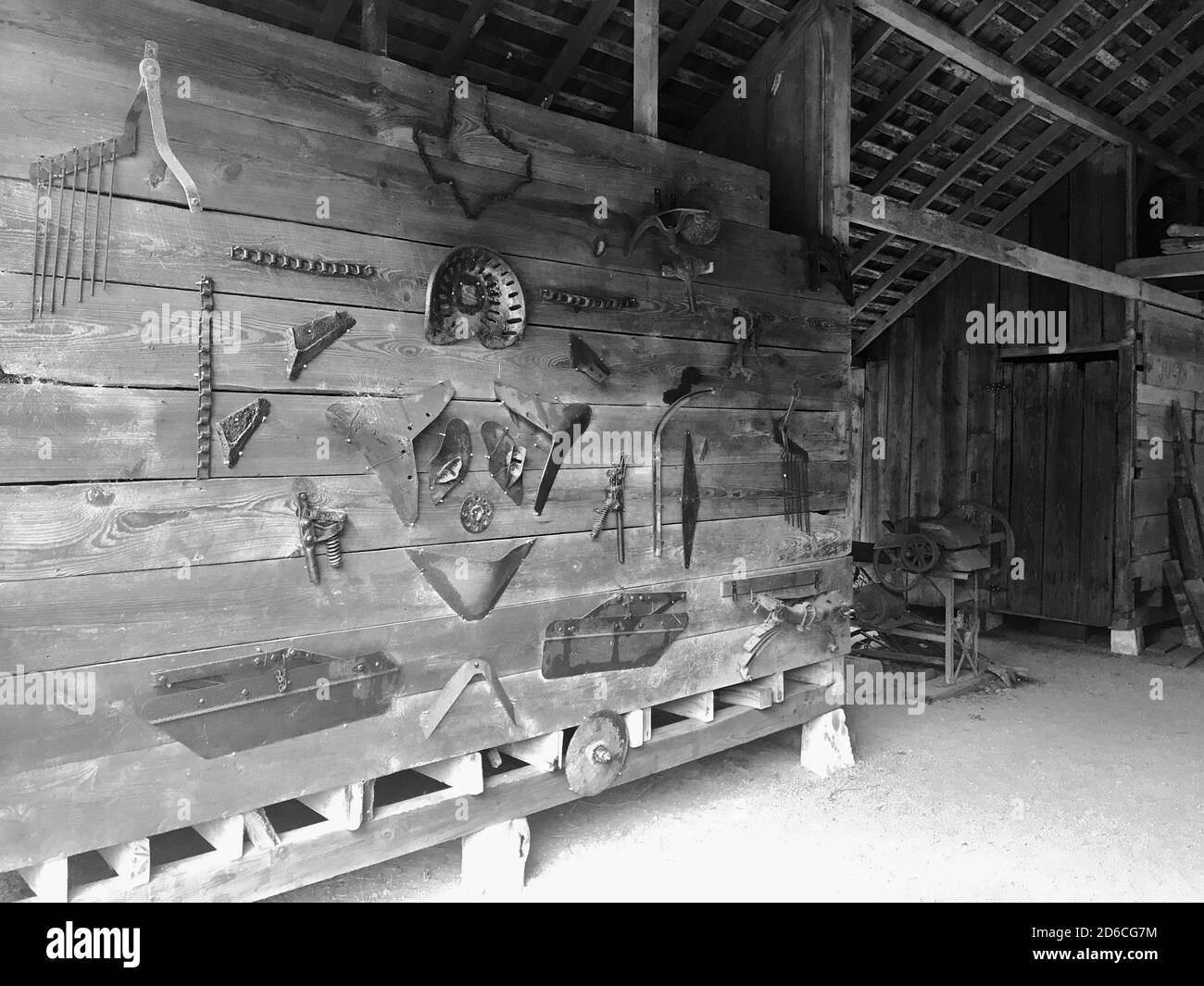 Elmer Kleb's primitive barn at Kleb Woods Nature Preserve in Tomball Texas displays an assortment of old farm tools displayed on wall. Stock Photo