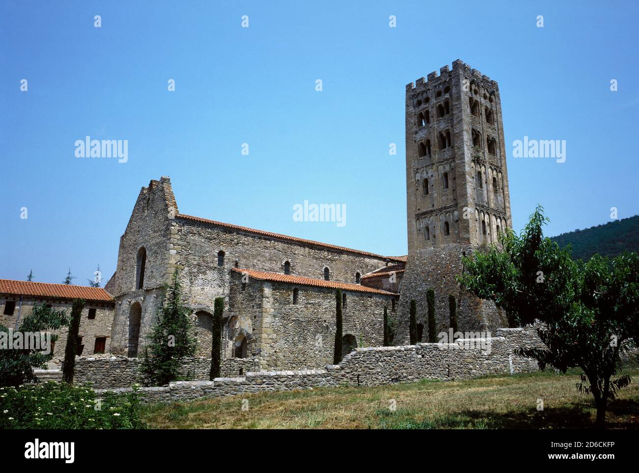 France. Pyrenees-Orientales departament. Occitanie Region. The Abbey of Saint-Michel de Cuxa. Benedictine abbey, consecrated in 974. Exterior view of the pre-Romanesque style church, 10th century and Lombard Romanesque bell tower, 11th century. Stock Photo