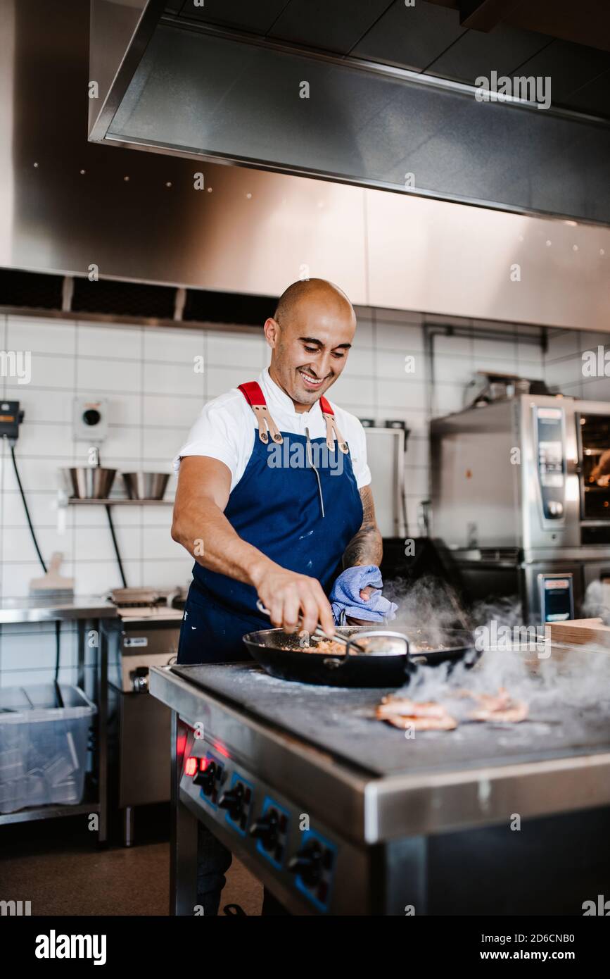 Smiling chef working in kitchen Stock Photo
