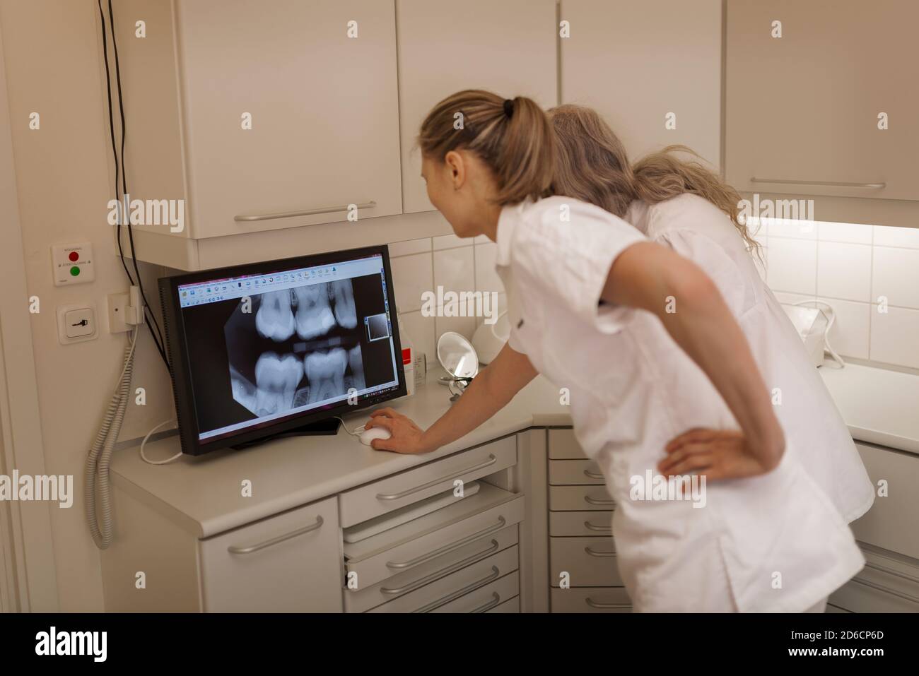 Dentist looking at x-ray on screen Stock Photo