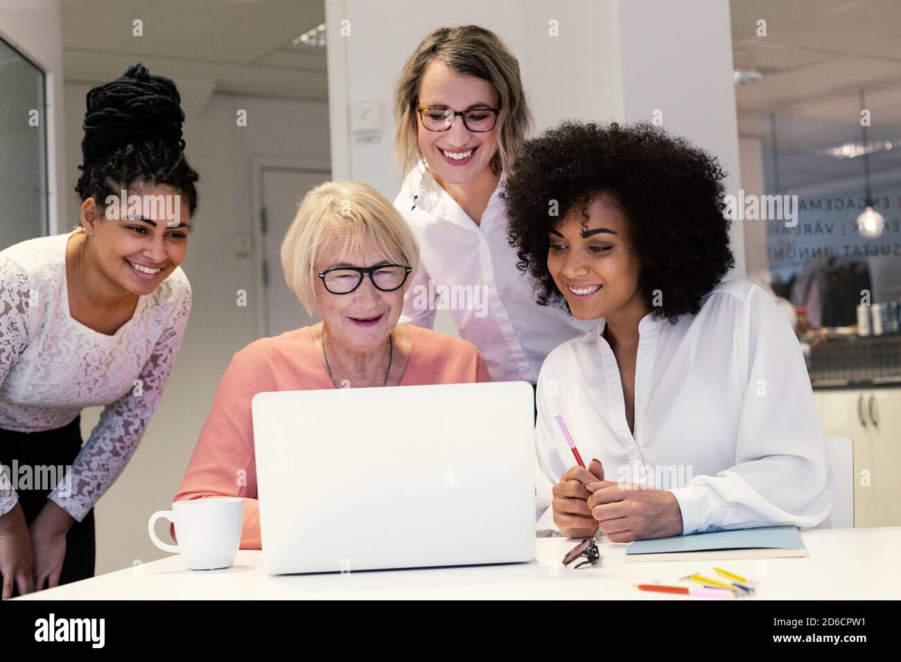 Women using laptop in boardroom Stock Photo