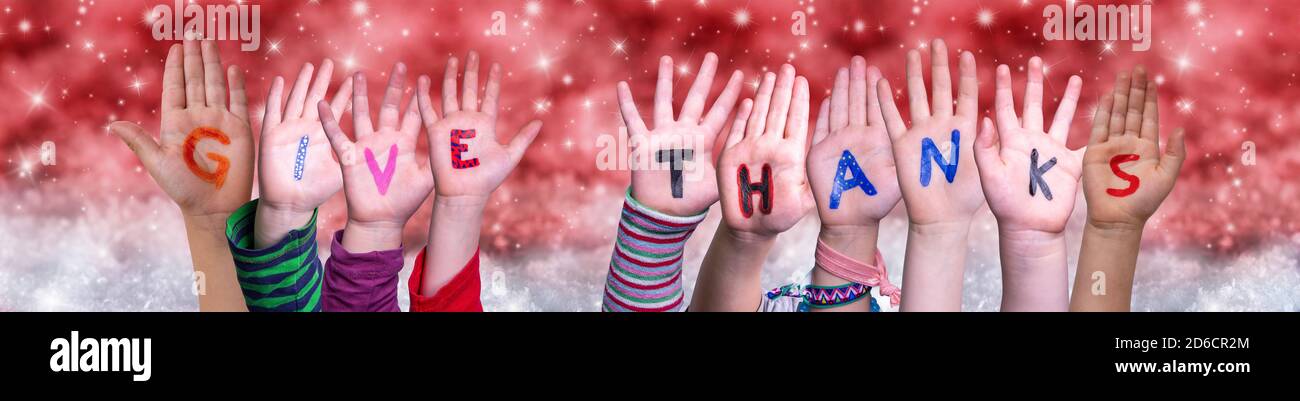 Children Hands Building Word Give Thanks, Red Christmas Background Stock Photo