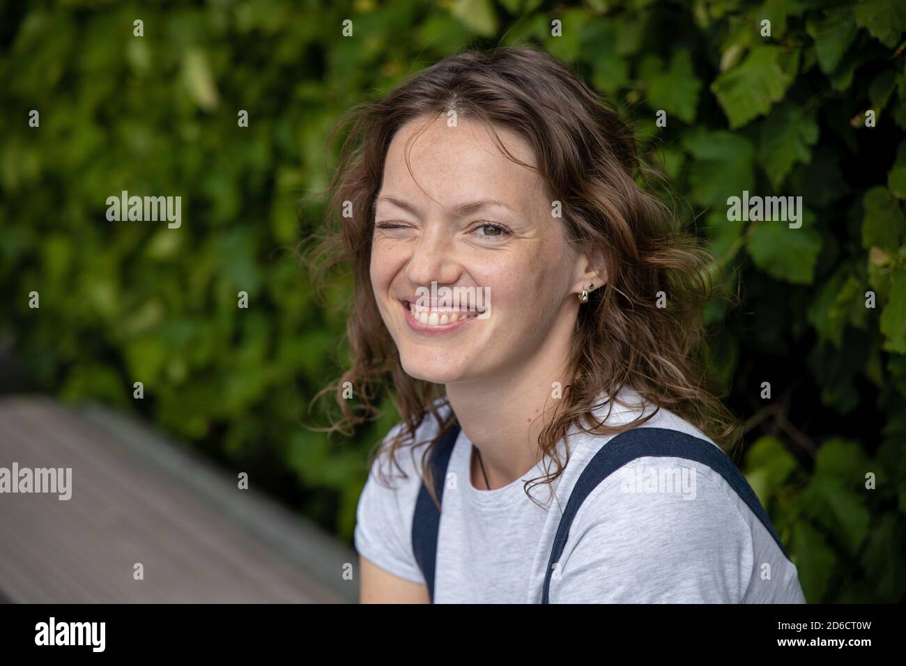 Close up shot of beautiful young female with positve expression, dressed in summer clothing, being in good mood after beauty procedures, sits at Stock Photo