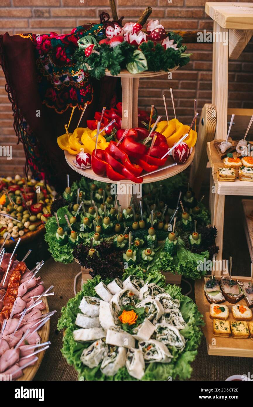 Festive snacks in a restaurant on wooden racks on a buffet table. Rustic style. Stock Photo