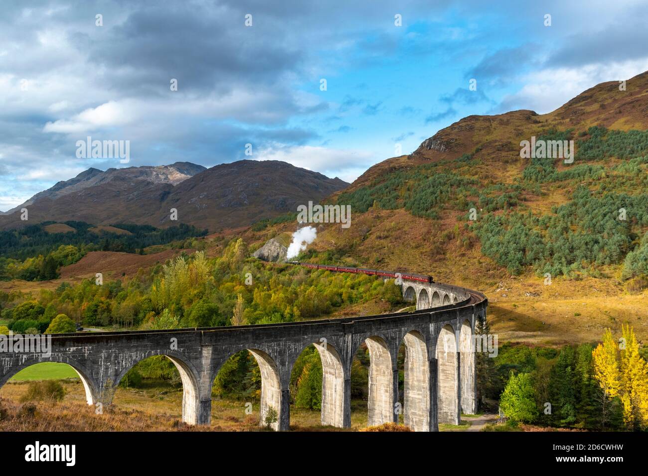 FORT WILLIAM WEST COAST OF SCOTLAND THE JACOBITE STEAM TRAIN LEAVING THE GLENFINNAN VIADUCT WITH AUTUMN COLOURS IN THE SCENERY Stock Photo