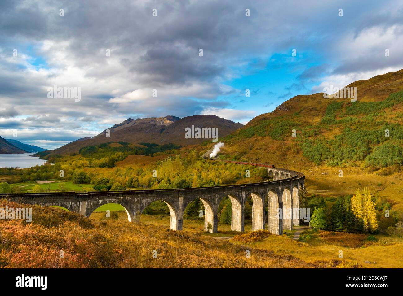 FORT WILLIAM WEST COAST OF SCOTLAND THE JACOBITE STEAM TRAIN LEAVING THE GLENFINNAN VIADUCT WITH AUTUMN COLOURS IN THE TRESS AND BRACKEN Stock Photo