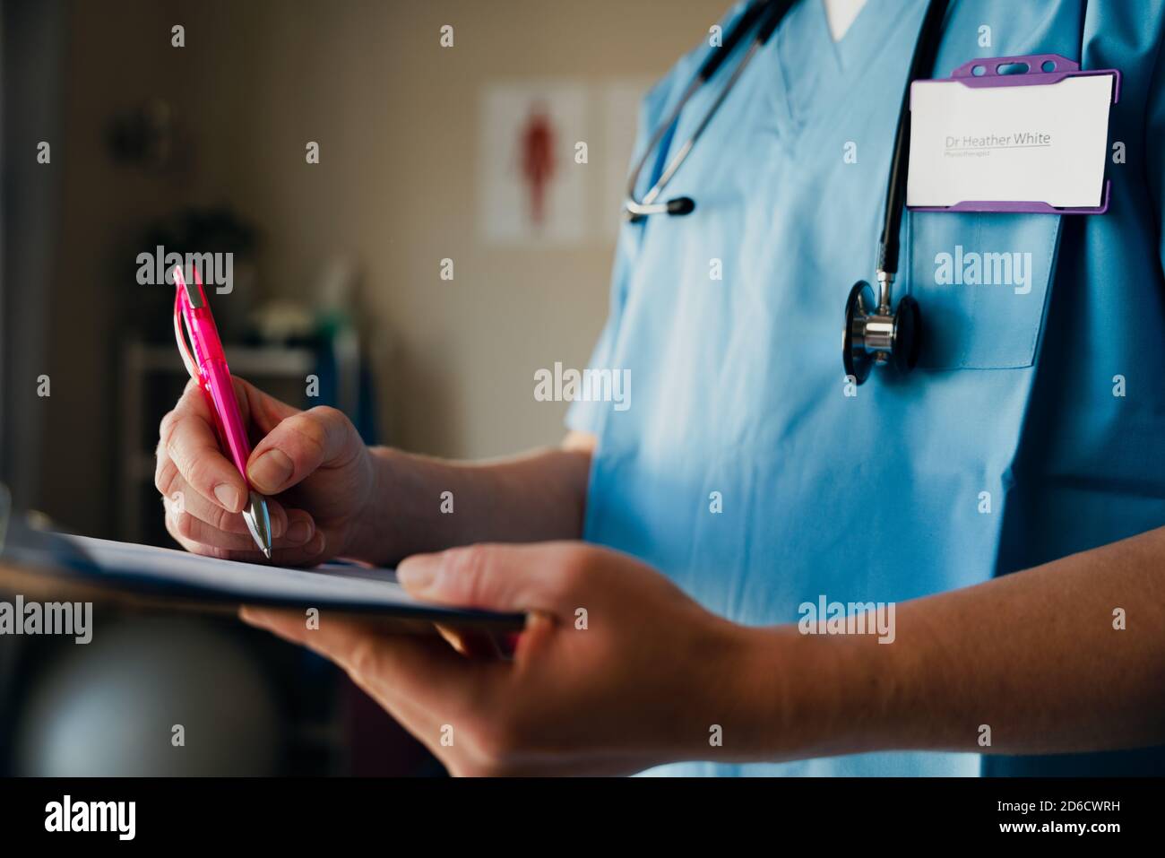 Close up of nurse writing on clipboard preparing for appointment with sick patient while standing in clinic Stock Photo