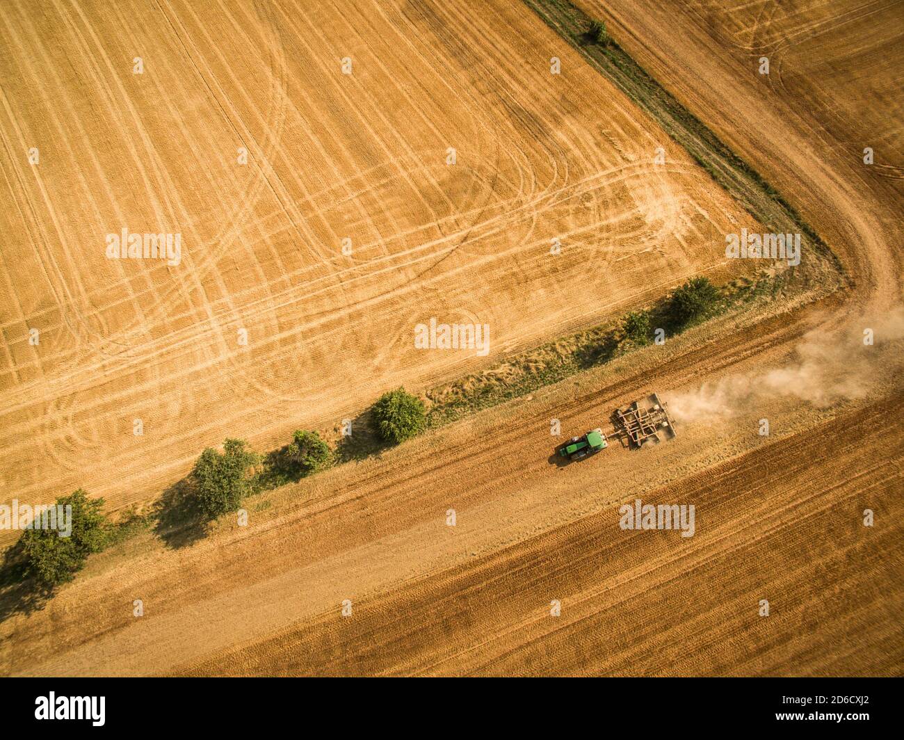 Aerial view of a tractor working a field after harvest Stock Photo - Alamy