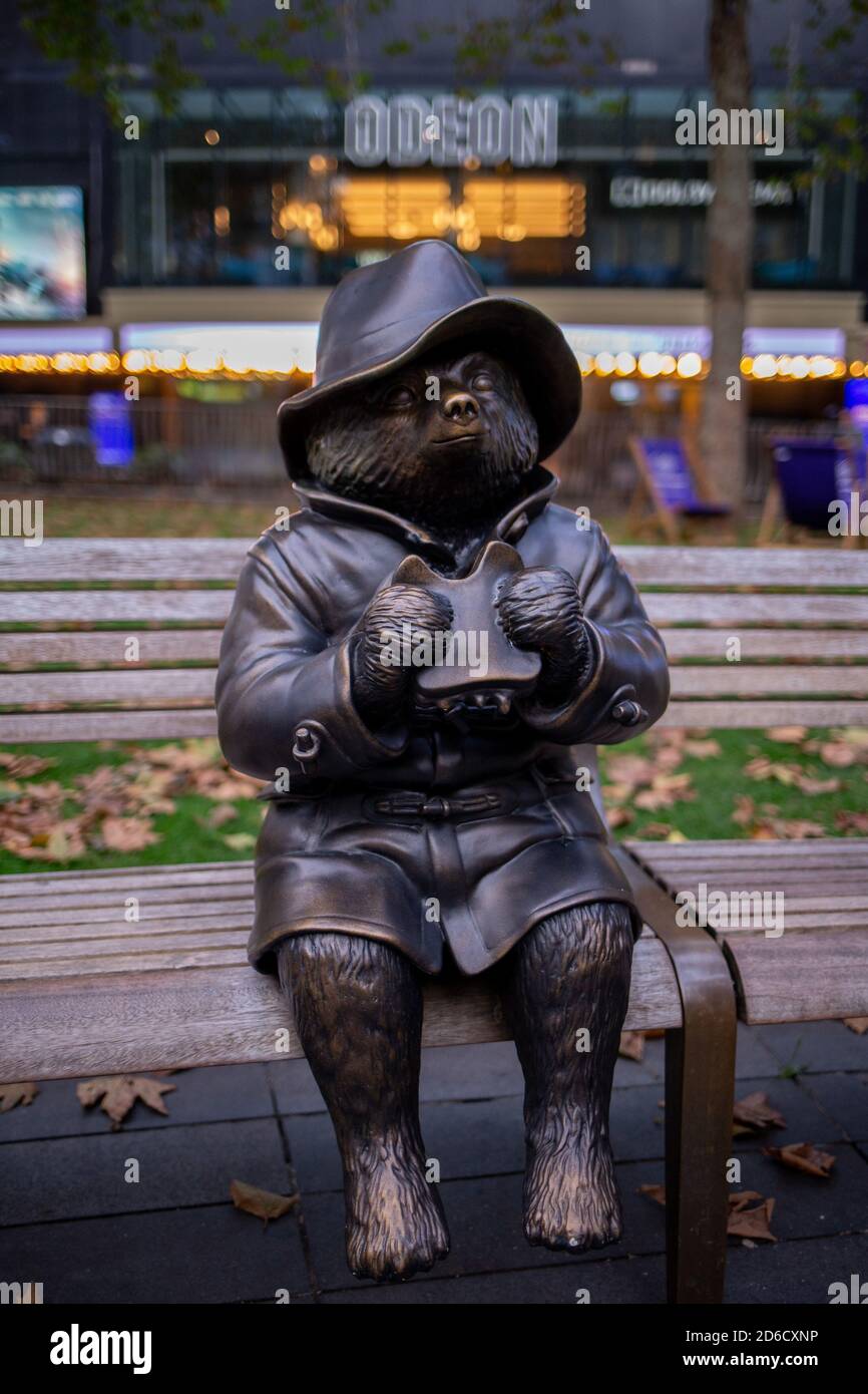 A bronze statue depicting a scene from a Paddington movie featuring