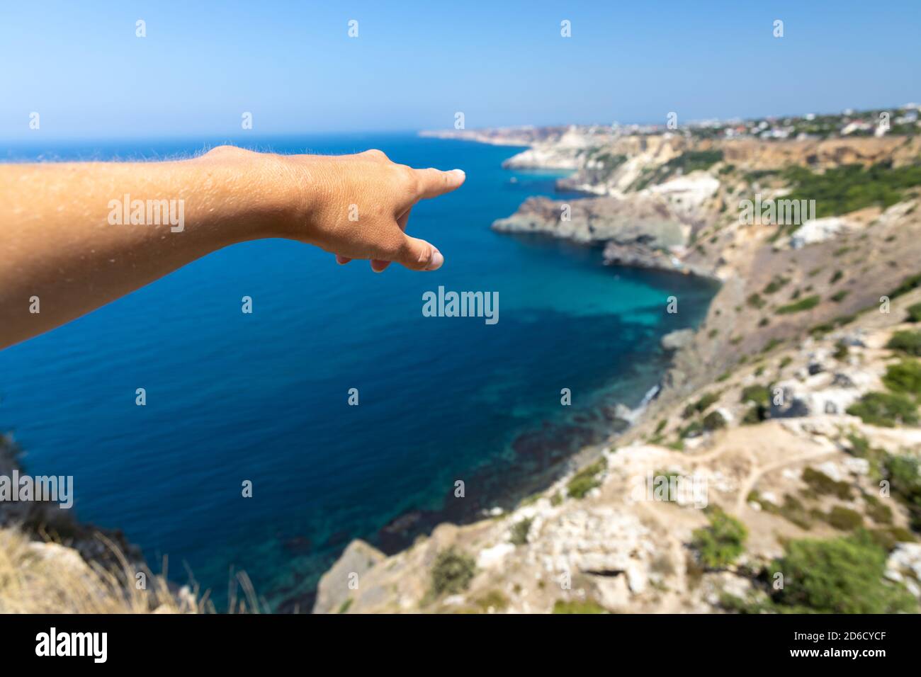 Young beautiful girl shows a hand on the sea Stock Photo