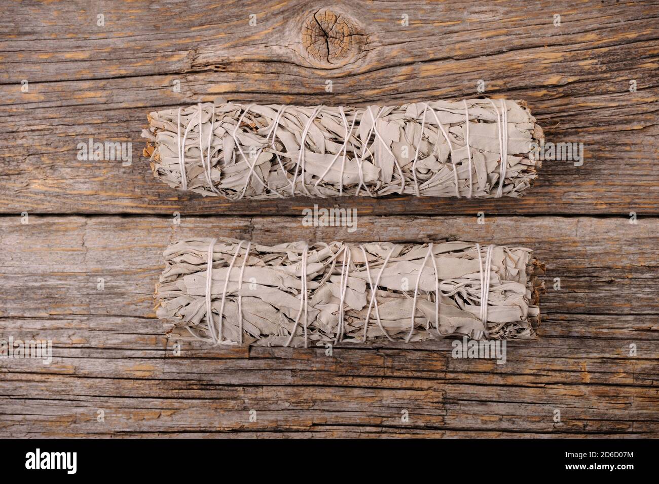 Dried white sage smudge bundles  on old distressed wood background.Aroma smoke for energy clearing and healing.Close up with space for text. Stock Photo
