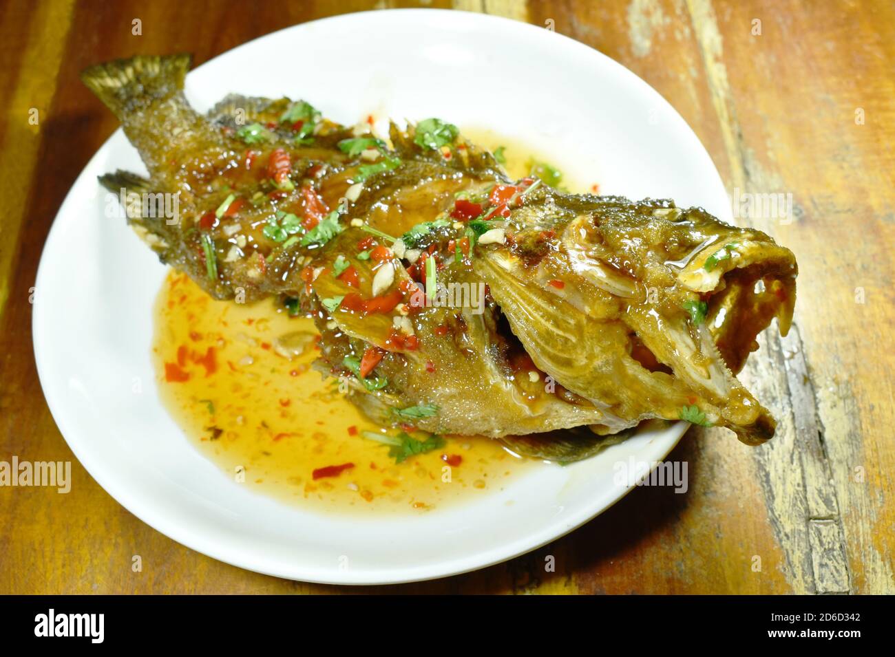 deep fried red banded grouper fish dressing sweet chili sauce on plate