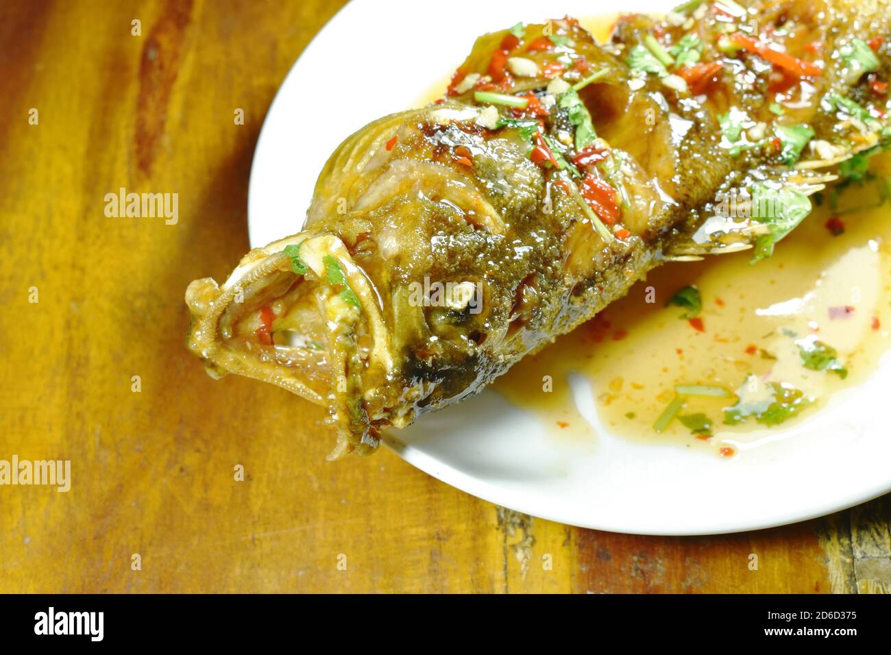 deep fried red banded grouper fish dressing sweet chili sauce on plate