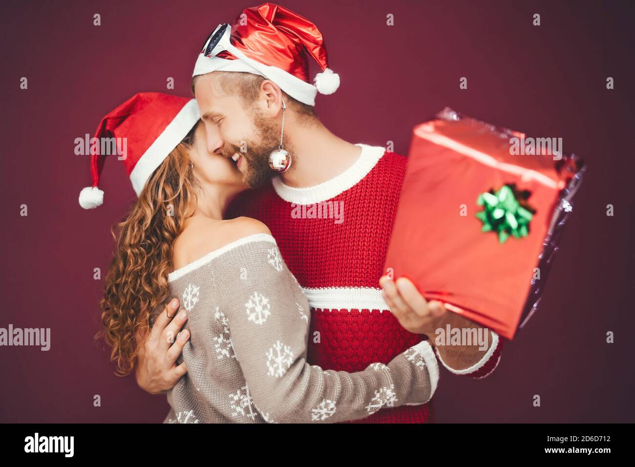 Happy couple celebrating Christmas time while sharing presents - Young lovers having fun during xmas holidays Stock Photo