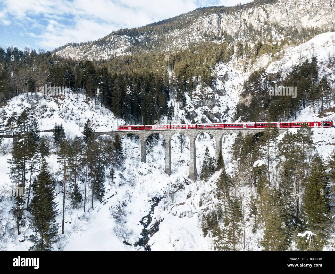 Filisur Switzerland - January 31. 2019: A red passenger Swiss train passing on the Schmitten viaduct, which is on the same line with Landwasser Viaduc Stock Photo