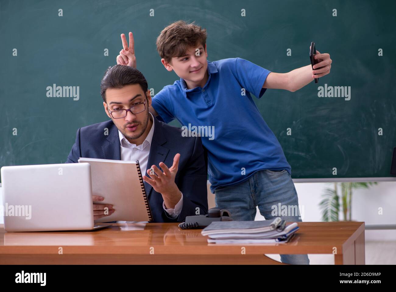 Male teacher and schoolboy in the classroom Stock Photo - Alamy