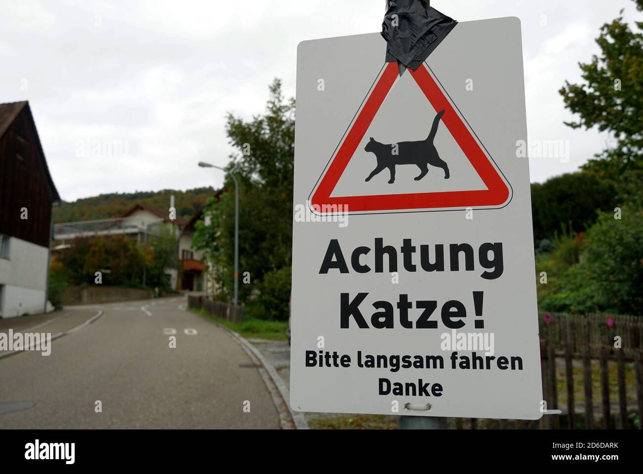 A traffic sign saying in German language: attention, beware of a cat, please drive slowly, thank you. The sign is located in town Weinfelden. Stock Photo