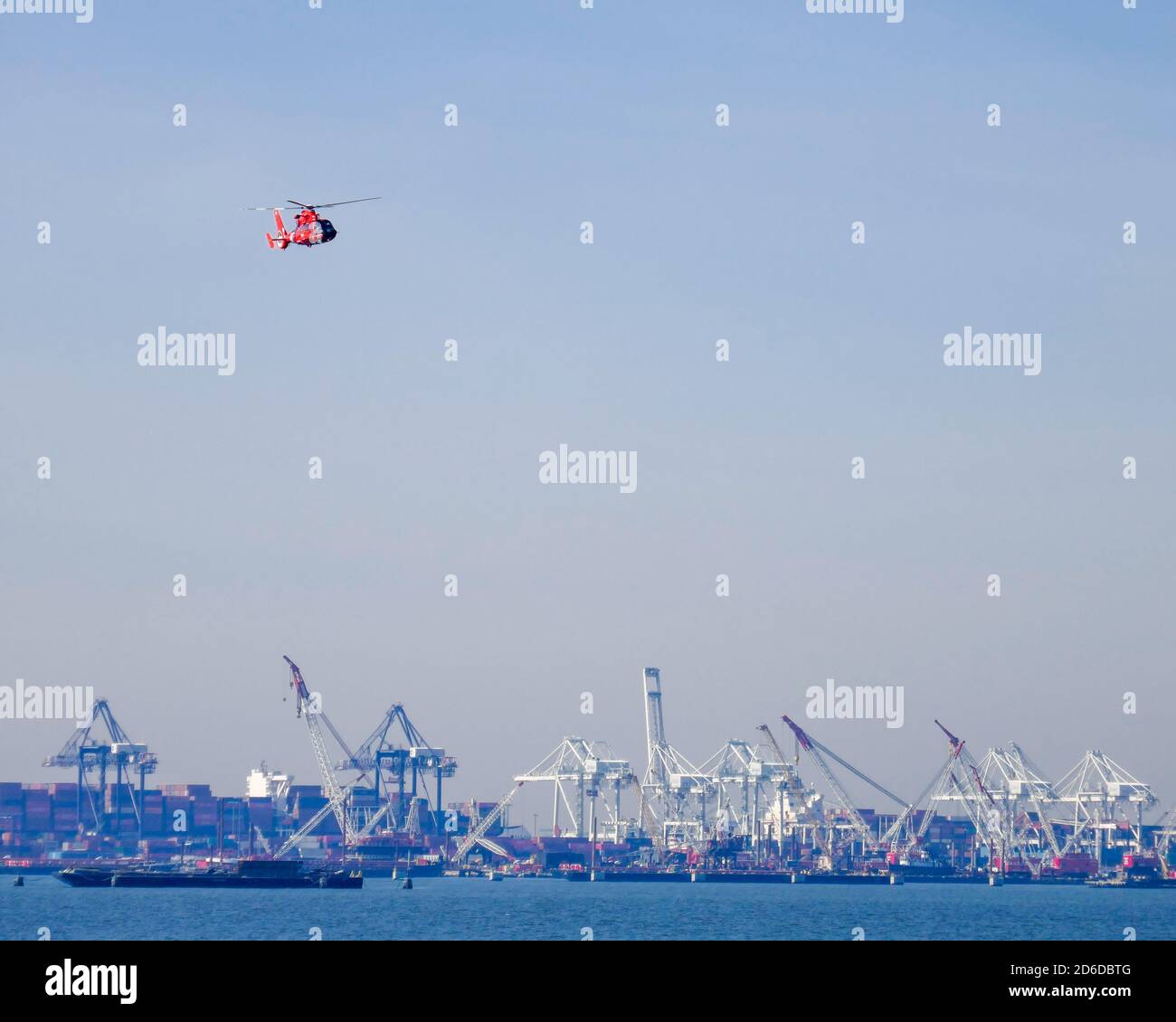 Colorful US Coast Guard helicopter flying over shipyards in New York ...
