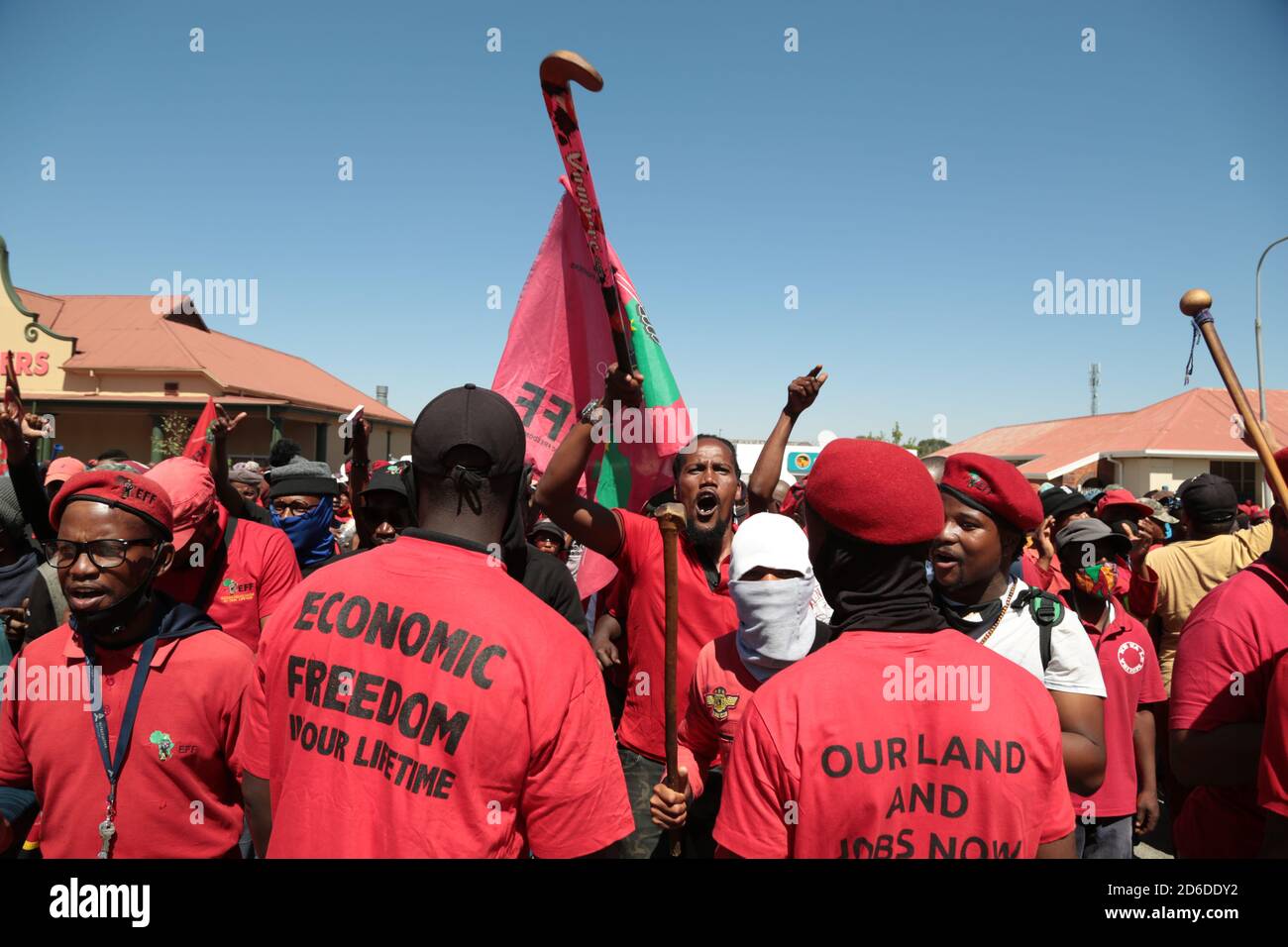 Members of the Economic Freedom Fighters (EFF) and Julius Malema supporters chant slogans outside the magistrates court during the protest.A tense standoff between white farmers and Black activists gripped the South African town of Senekal, as two men accused of killing a white farm manager were to appear in court. More than 100 police patrolled the area in front of the courthouse in the Free State province and used barbed wire to separate the rival groups. Stock Photo