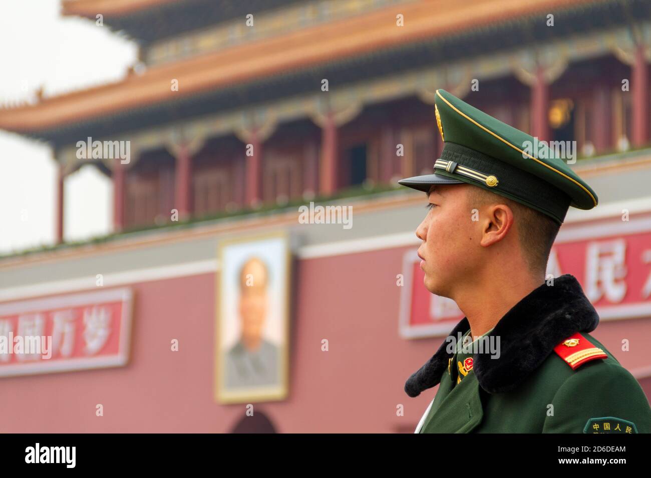 Beijing, China - November 21 2019: Young Chinese soldier guards the Gate of Heavenly Peace. On the sides of Mao's portrait is read 'Long live the Peop Stock Photo