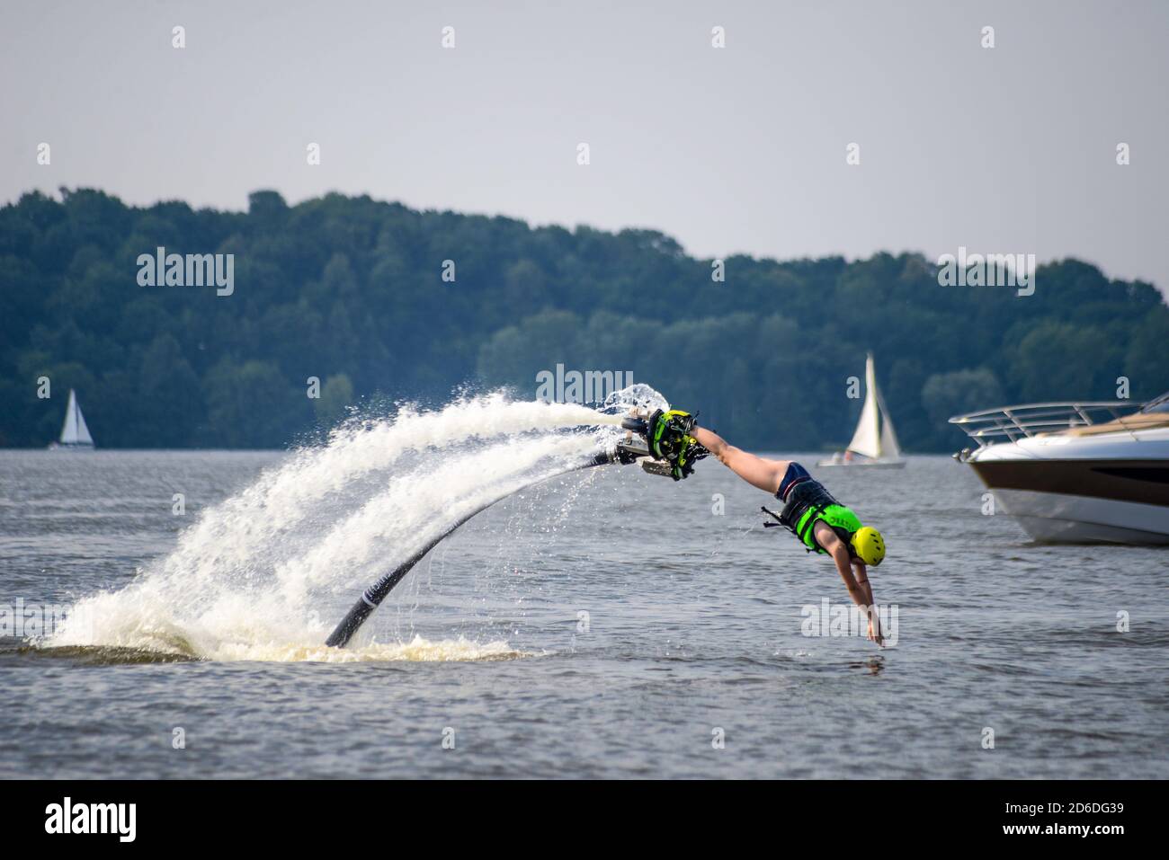 Young girl in jet boots is jumping into the lake - hydroflying. Stock Photo