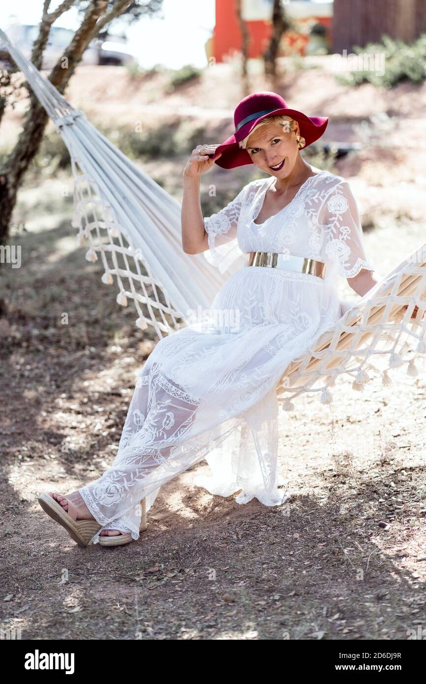 Elegant pregnant woman resting on outdoor hammock Stock Photo