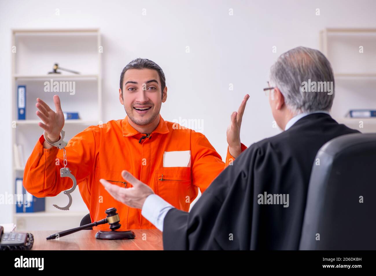 Old judge meeting with young captive in courthouse Stock Photo Alamy