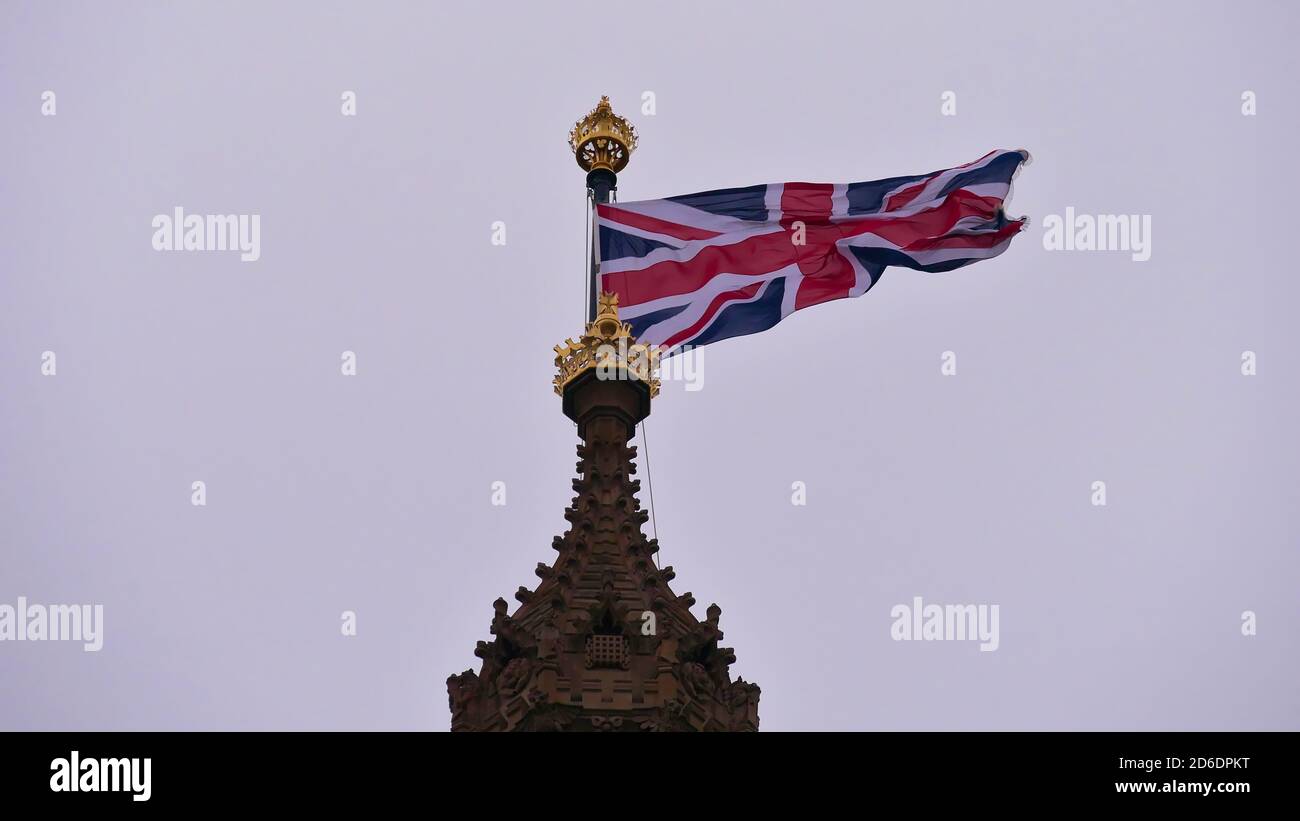 Closeup view of British Union Jack, the national flag of United Kingdom, waving in strong wind on the top of Victoria Tower, Palace of Westminster. Stock Photo