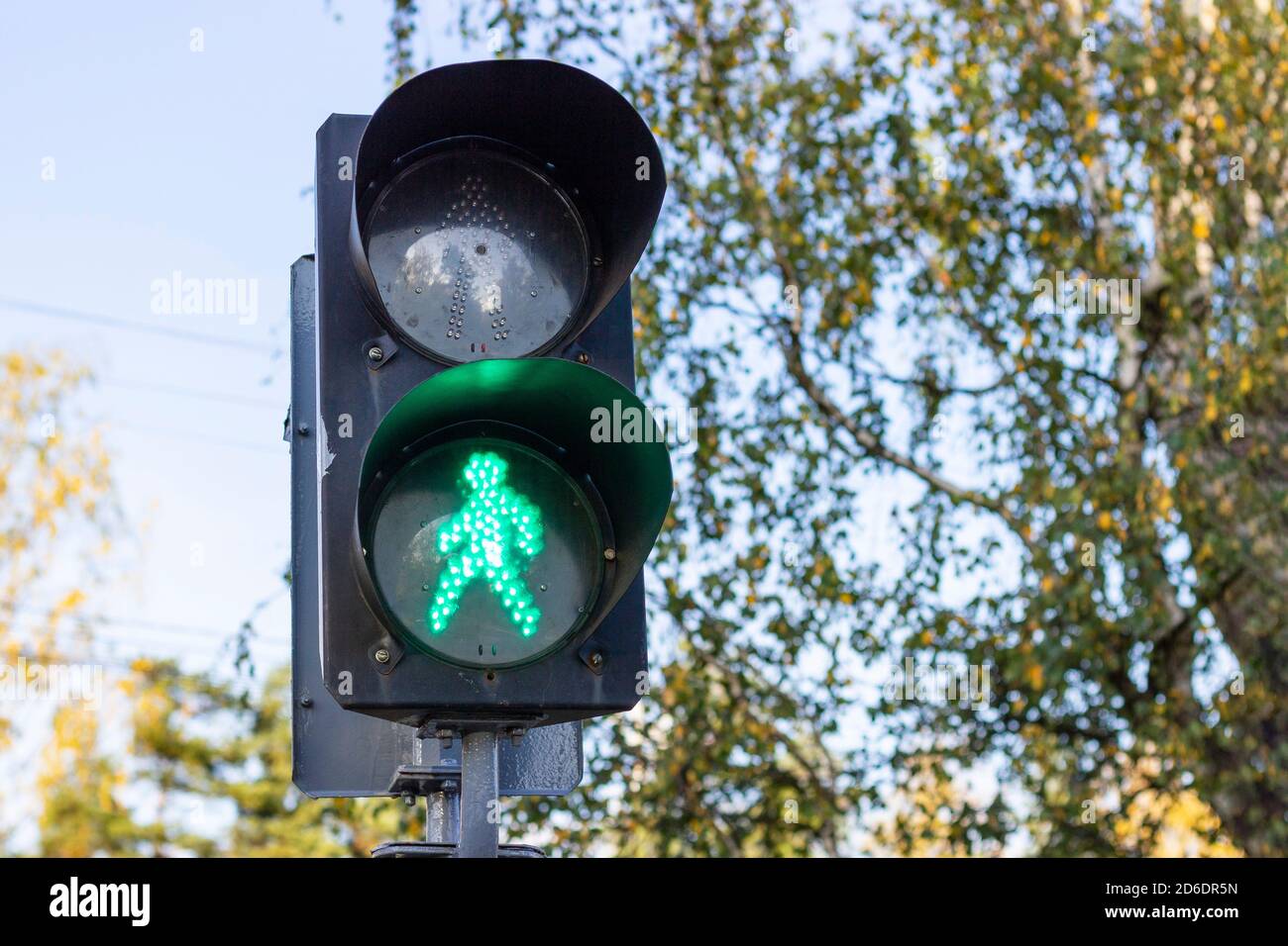 Permissive green traffic light at a pedestrian crossing. Stock Photo